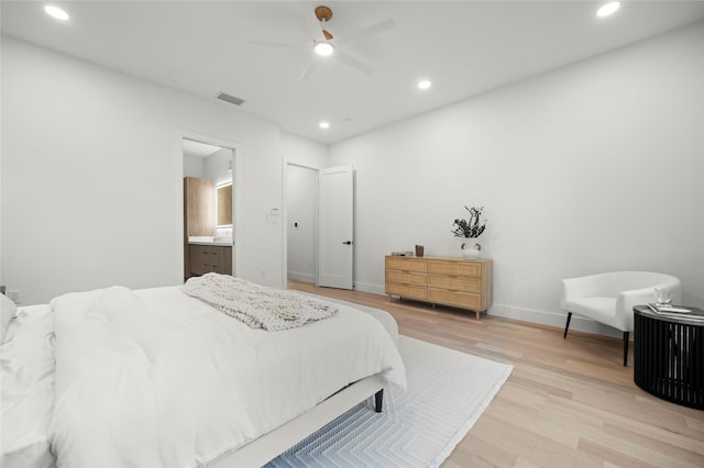 bedroom featuring ceiling fan, connected bathroom, and light hardwood / wood-style flooring