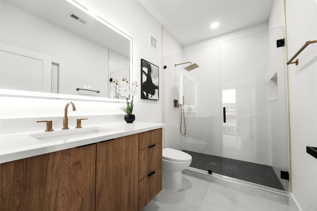 bathroom with vanity, walk in shower, tile patterned floors, and toilet