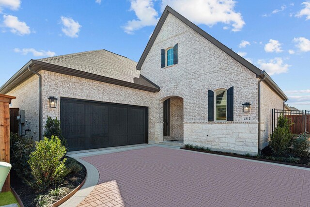 french country style house with a garage and a front lawn