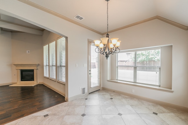 unfurnished dining area featuring light hardwood / wood-style flooring, a chandelier, vaulted ceiling, and a healthy amount of sunlight