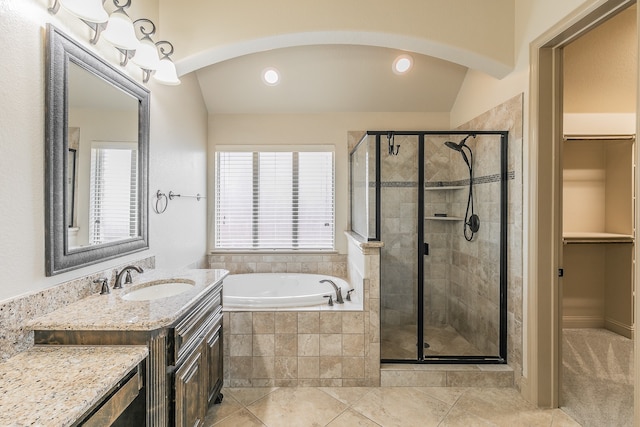 bathroom with plus walk in shower, vanity, lofted ceiling, and a healthy amount of sunlight