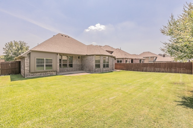 back of house with a yard and a patio area