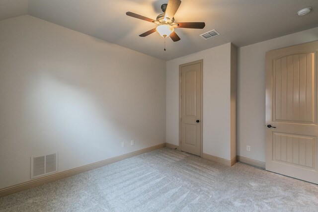 unfurnished bedroom featuring lofted ceiling, light carpet, and ceiling fan