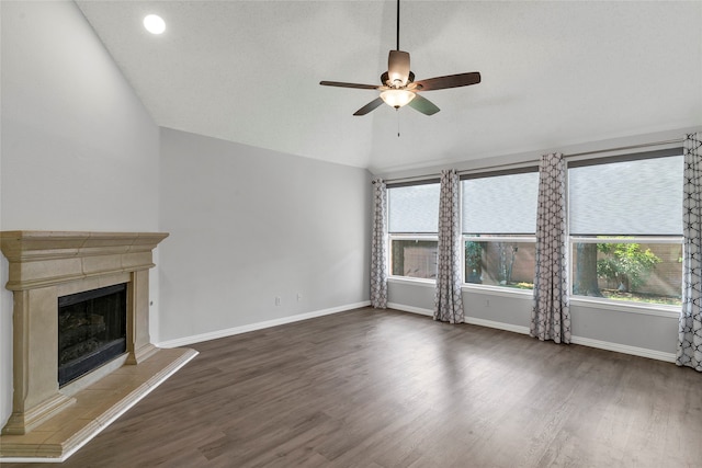 unfurnished living room with a tiled fireplace, lofted ceiling, ceiling fan, and wood-type flooring