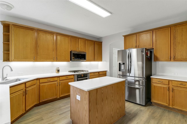 kitchen featuring light hardwood / wood-style flooring, appliances with stainless steel finishes, a center island, and sink