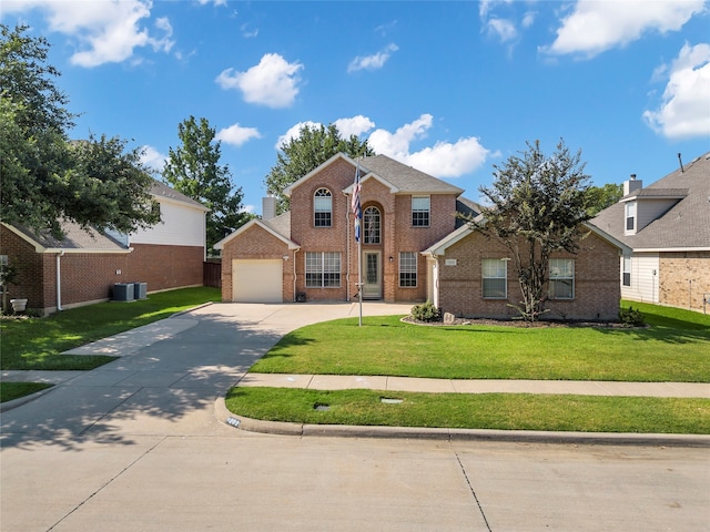 front of property with a garage, central air condition unit, and a front yard