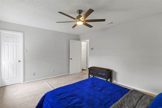 carpeted bedroom featuring ceiling fan and a textured ceiling