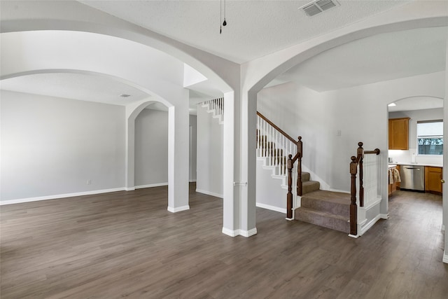 entrance foyer with a textured ceiling and dark hardwood / wood-style flooring