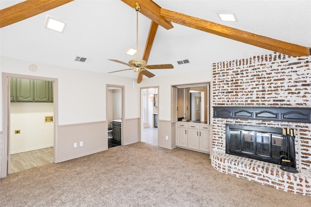 unfurnished living room with ceiling fan, a fireplace, light carpet, and vaulted ceiling with beams