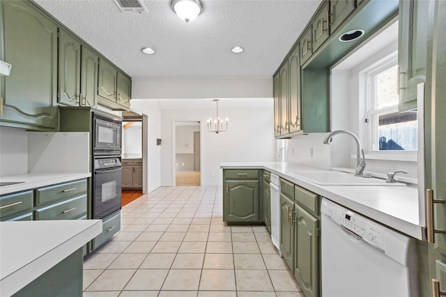 kitchen with sink, light tile patterned floors, white dishwasher, black oven, and green cabinets