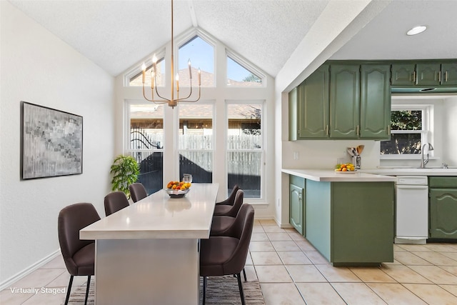 kitchen featuring sink, green cabinetry, vaulted ceiling, light tile patterned floors, and a kitchen breakfast bar