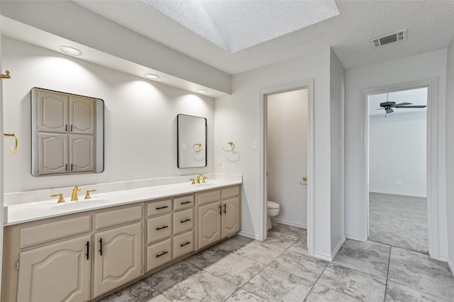 bathroom featuring vanity, toilet, and a textured ceiling