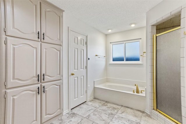 bathroom featuring separate shower and tub and a textured ceiling