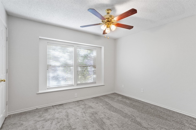 carpeted spare room featuring ceiling fan and a textured ceiling