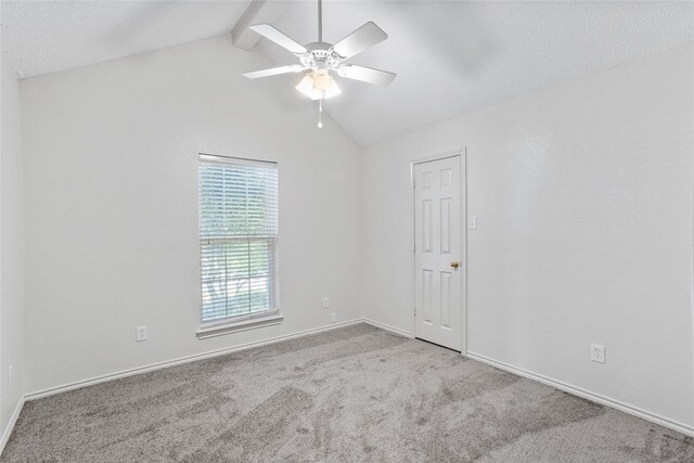 carpeted empty room featuring vaulted ceiling with beams and ceiling fan