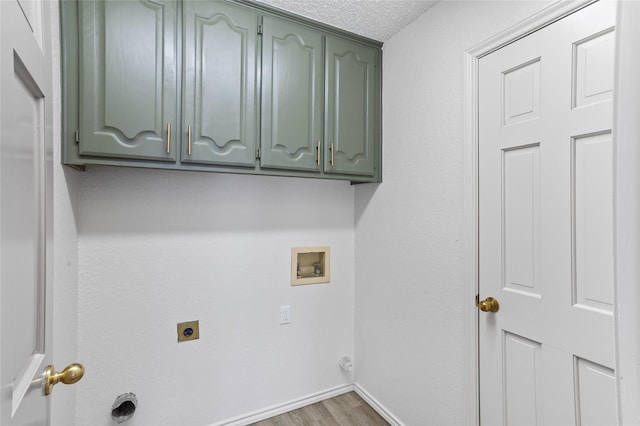 washroom featuring dark wood-type flooring, cabinets, washer hookup, a textured ceiling, and hookup for an electric dryer