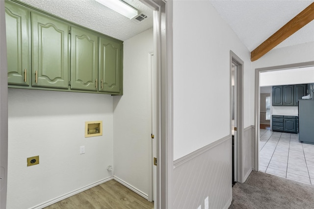 laundry room with electric dryer hookup, cabinets, washer hookup, a textured ceiling, and light colored carpet