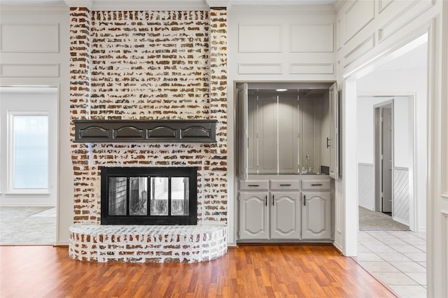 unfurnished living room with a brick fireplace and light wood-type flooring