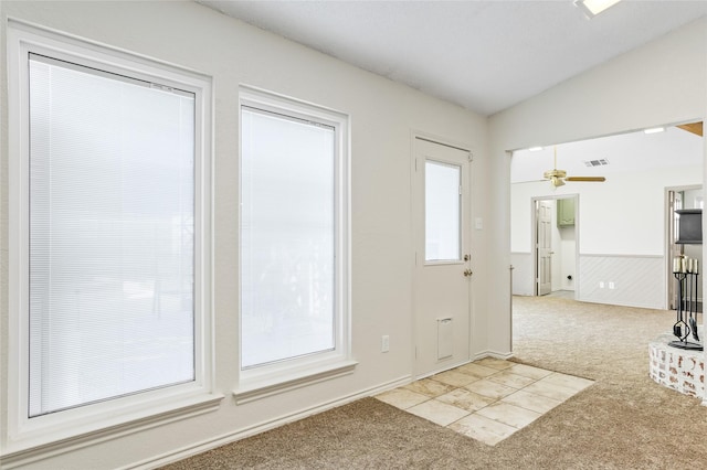 doorway with light carpet, vaulted ceiling, and ceiling fan