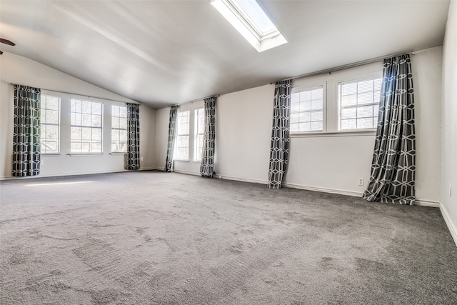 spare room featuring lofted ceiling with skylight and carpet floors