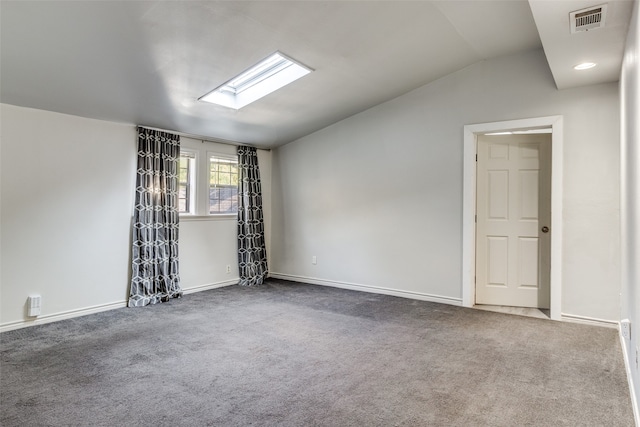 unfurnished room featuring vaulted ceiling with skylight and carpet