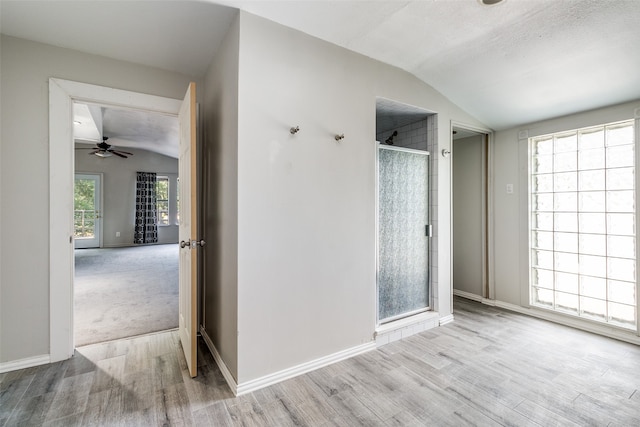 bathroom featuring hardwood / wood-style floors, ceiling fan, lofted ceiling, and a textured ceiling