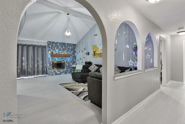 living room with visible vents, a large fireplace, baseboards, vaulted ceiling with beams, and a textured wall