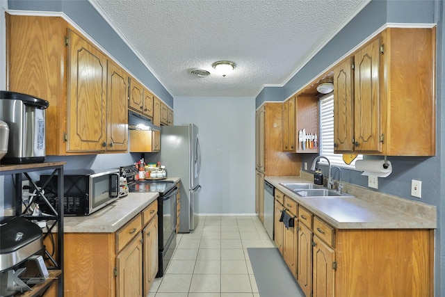 kitchen featuring stainless steel appliances, sink, light tile patterned floors, and a textured ceiling