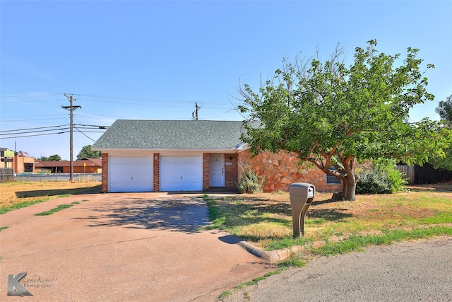 view of front of home featuring a garage, a shingled roof, driveway, and fence