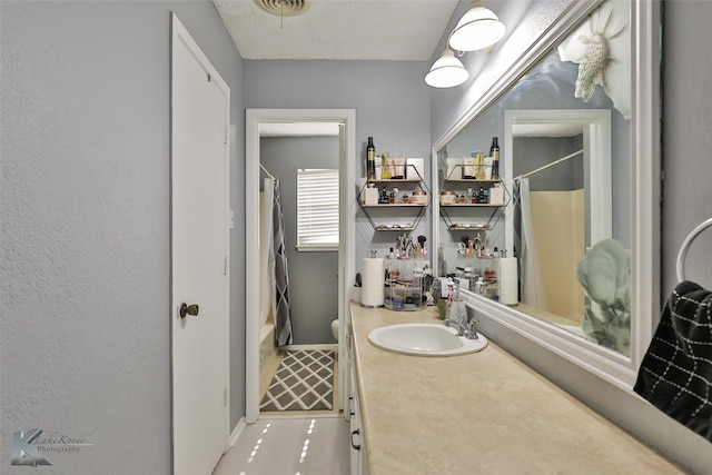 bathroom with vanity, toilet, a shower with shower curtain, and a textured ceiling