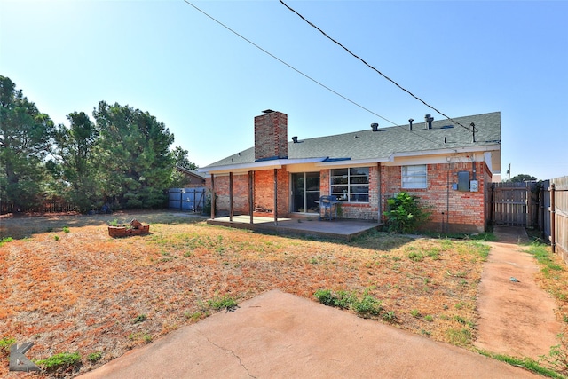 back of property featuring a patio and an outdoor fire pit