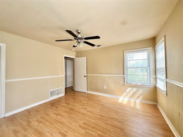 empty room featuring light wood-type flooring and ceiling fan