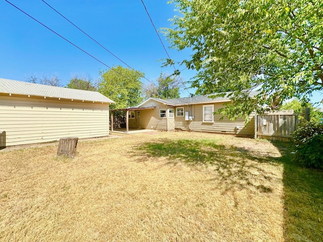 back of house featuring a lawn and fence