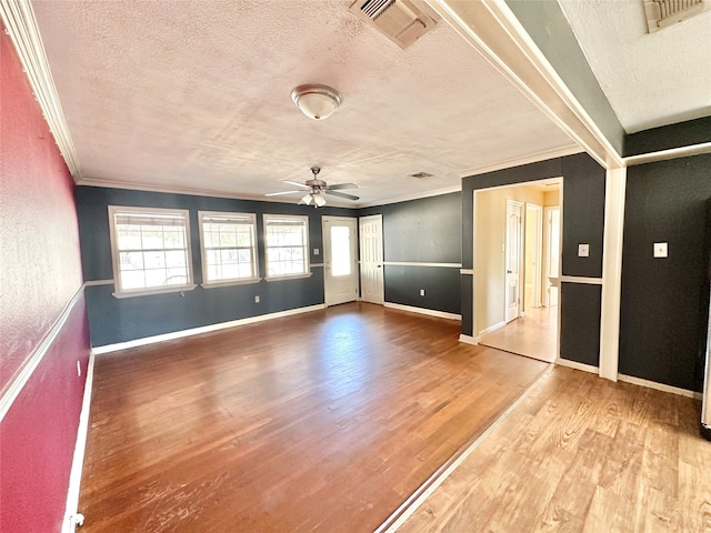 spare room featuring ceiling fan, hardwood / wood-style flooring, a textured ceiling, and ornamental molding