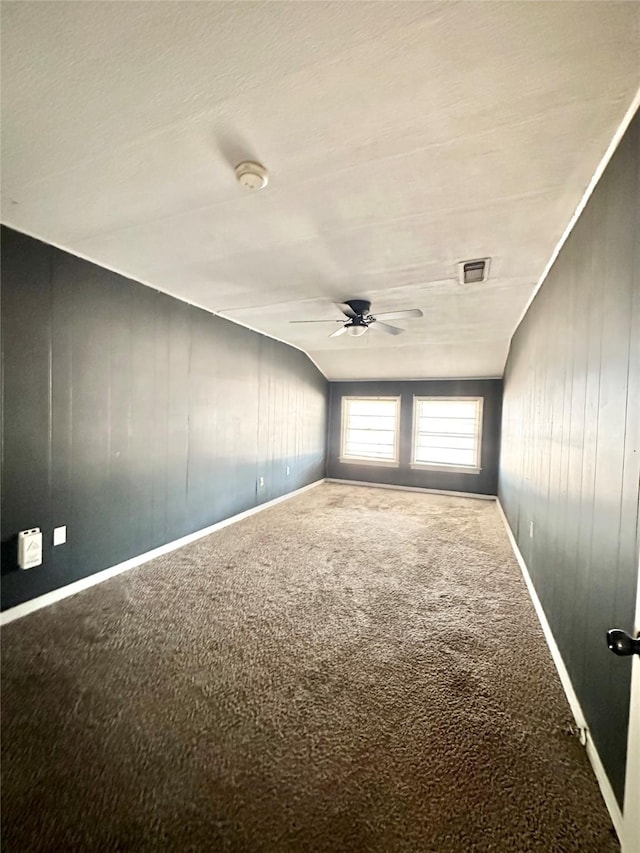 empty room with carpet floors, ceiling fan, visible vents, and baseboards