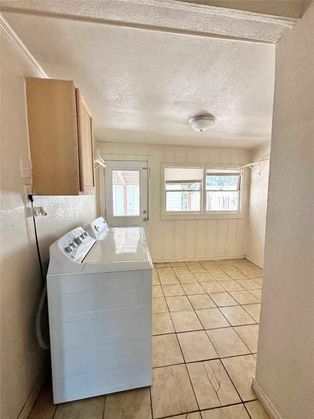 clothes washing area with a wealth of natural light, a textured ceiling, and washing machine and clothes dryer