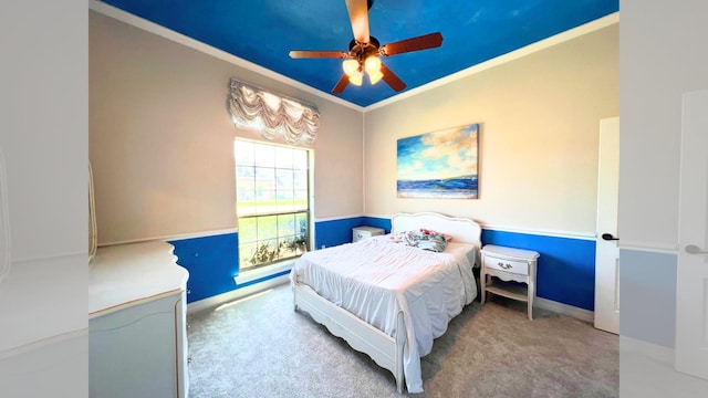 carpeted bedroom featuring ceiling fan and crown molding