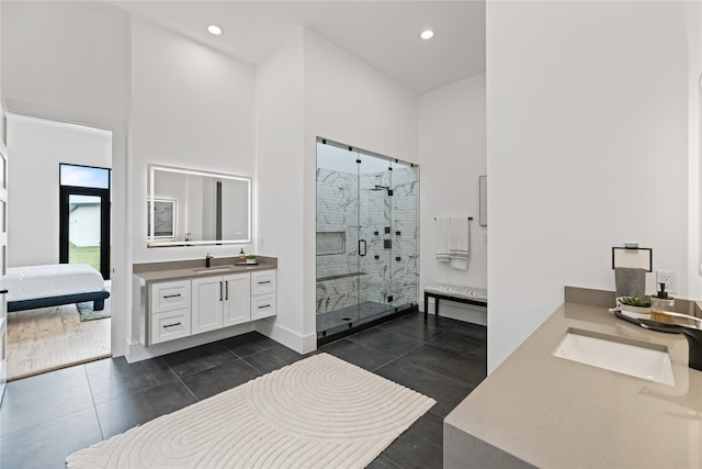 bathroom with a shower with shower door, a towering ceiling, vanity, and tile patterned flooring