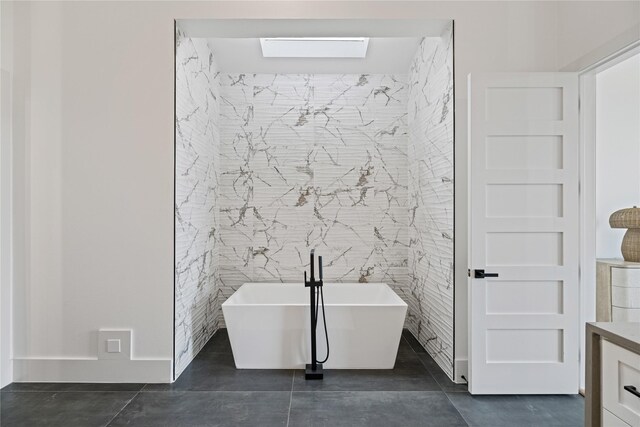 bathroom with tile walls, a washtub, and tile patterned floors