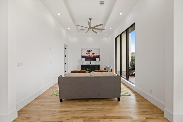 living room featuring ceiling fan, light hardwood / wood-style flooring, and plenty of natural light