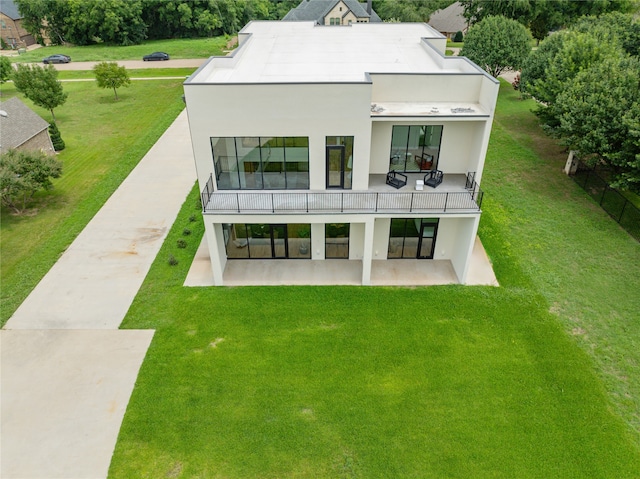 rear view of house featuring a patio area and a lawn