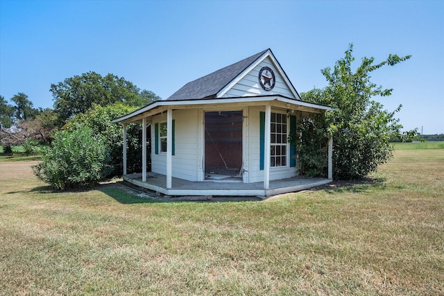 view of front of house with a front yard and an outdoor structure