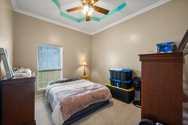 bedroom with carpet floors, a raised ceiling, crown molding, and ceiling fan