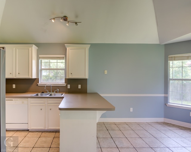 kitchen featuring white dishwasher, light tile patterned floors, sink, and white cabinetry