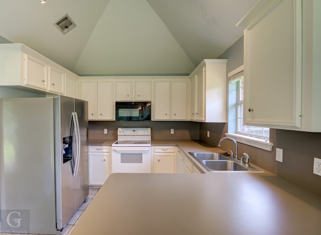 kitchen with light tile patterned floors, white electric stove, sink, white cabinetry, and stainless steel fridge