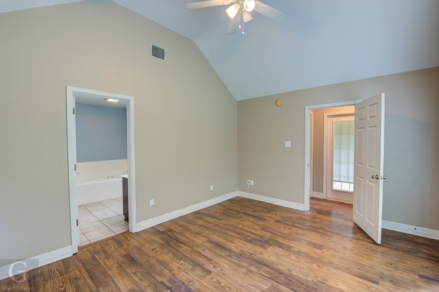 unfurnished bedroom with lofted ceiling, wood-type flooring, ensuite bathroom, and ceiling fan