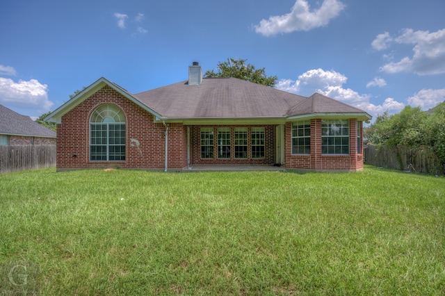 rear view of house with a patio area and a yard