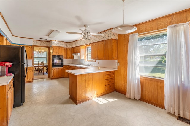 kitchen featuring kitchen peninsula, hanging light fixtures, a wealth of natural light, and black appliances