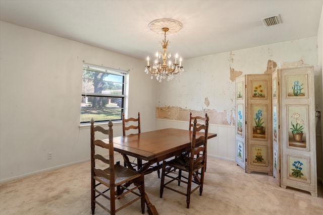 dining room featuring light colored carpet and a notable chandelier