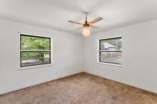 empty room featuring carpet flooring, a wealth of natural light, and ceiling fan